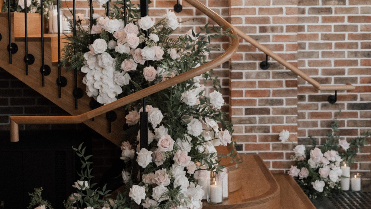 Premium high quality silk faux floral design installed on a spiral staircase for a wedding