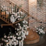 Premium high quality silk faux floral design installed on a spiral staircase for a wedding