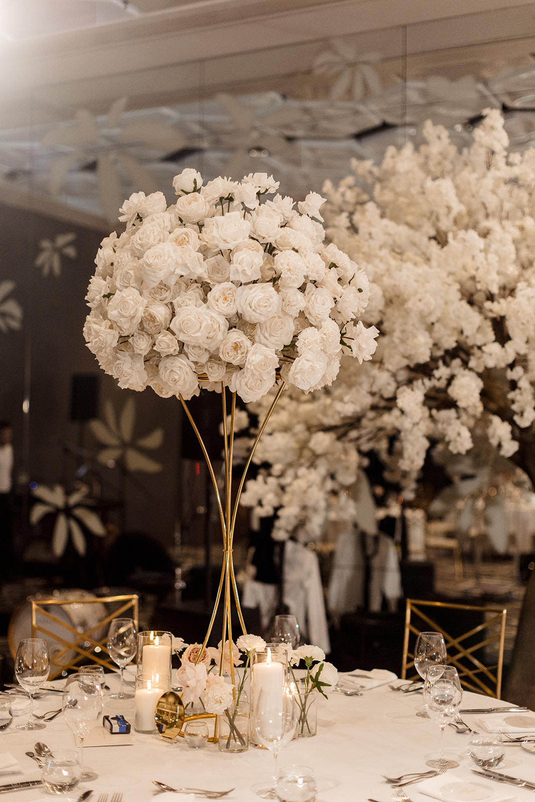 Elevated white faux florals on gold stands for modern wedding styling.